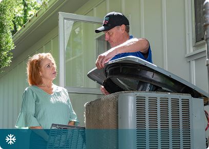 Cooling services: Academy Air technician opening an outdoor air conditioner while the homeowner watches