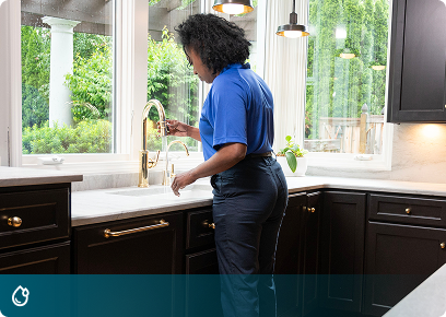 Plumbing services: Academy Air technician checking a kitchen sink faucet