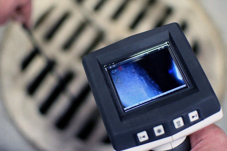 An experienced plumber holding a camera drain inspection device to identify the clog or blockage that is preventing a drain from draining properly. For camera drain cleaning services in Fenton, MO, call your local plumber.
